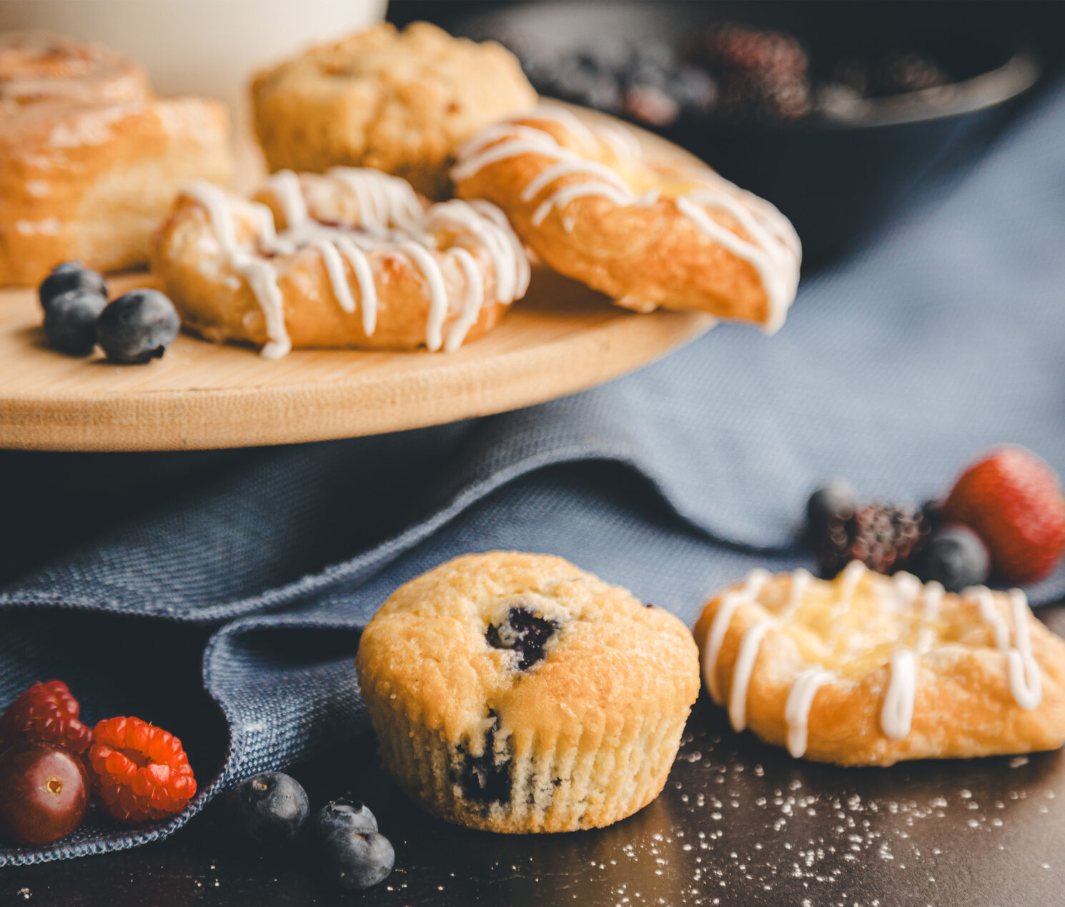 assortment of breakfast pastries, muffins, danishes, and fruit